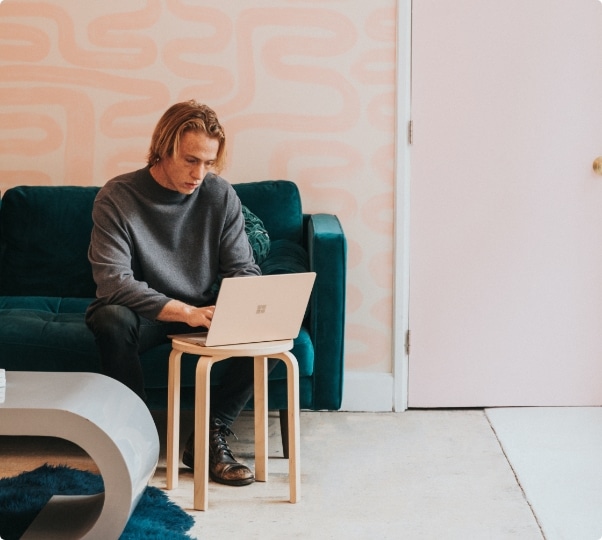 Mies käyttää kannettavaa tietokonetta